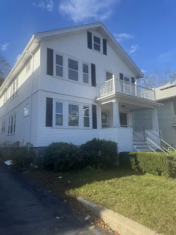 a front view of a house with a garden
