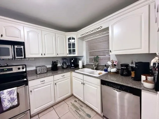 a kitchen with stainless steel appliances granite countertop a refrigerator and a stove