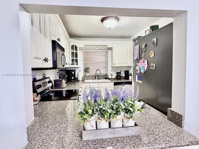 9491 Evergreen Place, Unit 102 Davie, FL 33324 - Photo 17 of 30 a kitchen with stainless steel appliances granite countertop a refrigerator and a stove