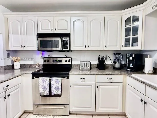 a kitchen with stainless steel appliances granite countertop a refrigerator stove and sink