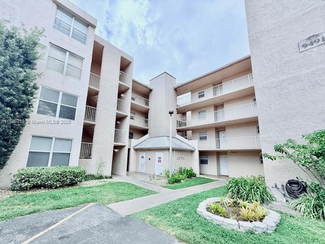 9491 Evergreen Place, Unit 102 Davie, FL 33324 - Photo 2 of 30 a view of a brick building next to a yard