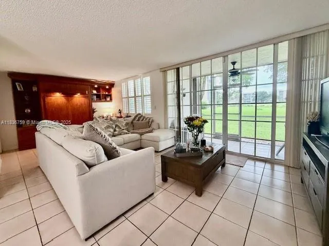 a living room with furniture and a floor to ceiling window