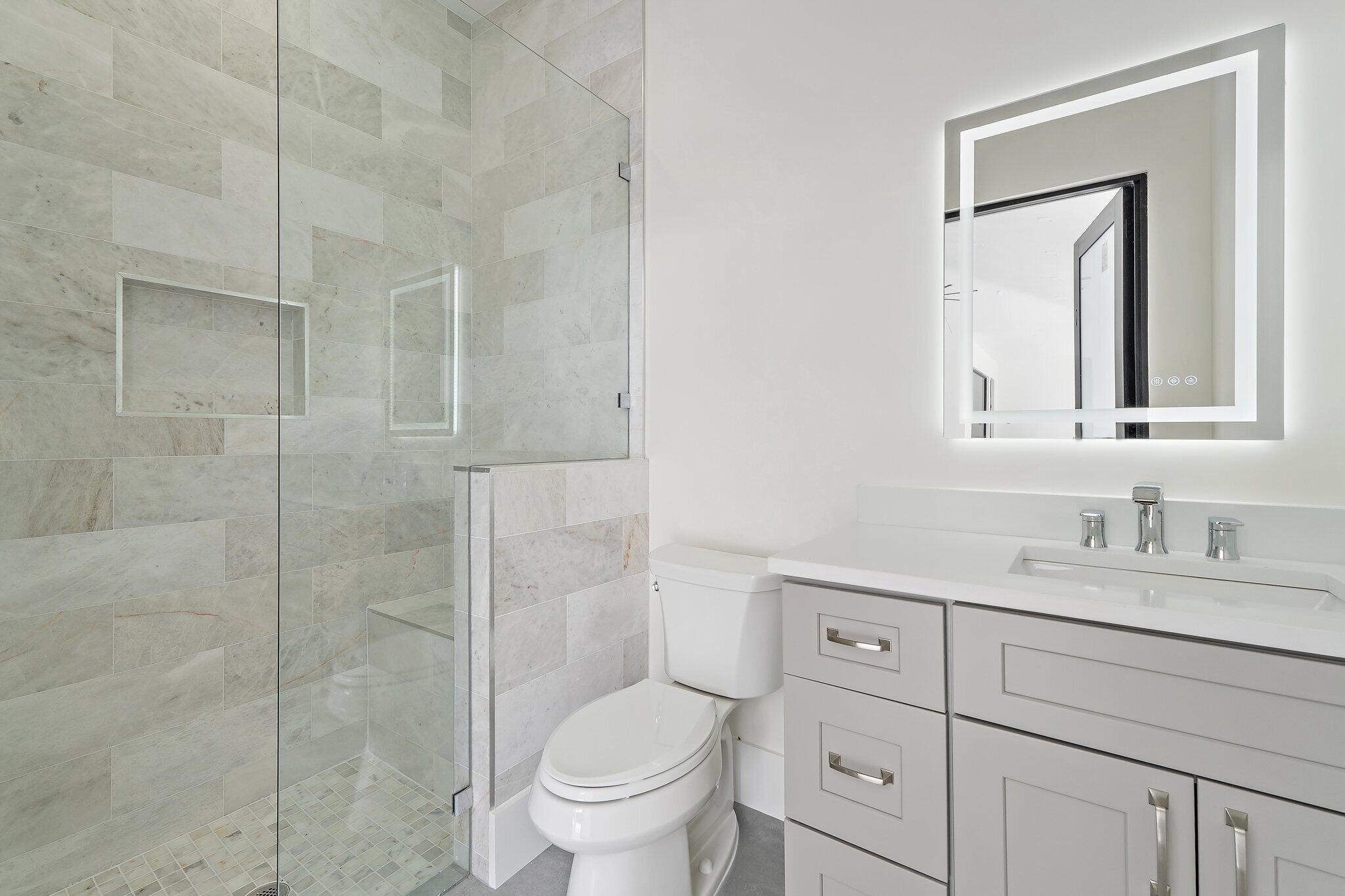 12850 152nd Street North Jupiter, FL 33478 - Photo 106 of 117 a bathroom with a toilet sink vanity and shower