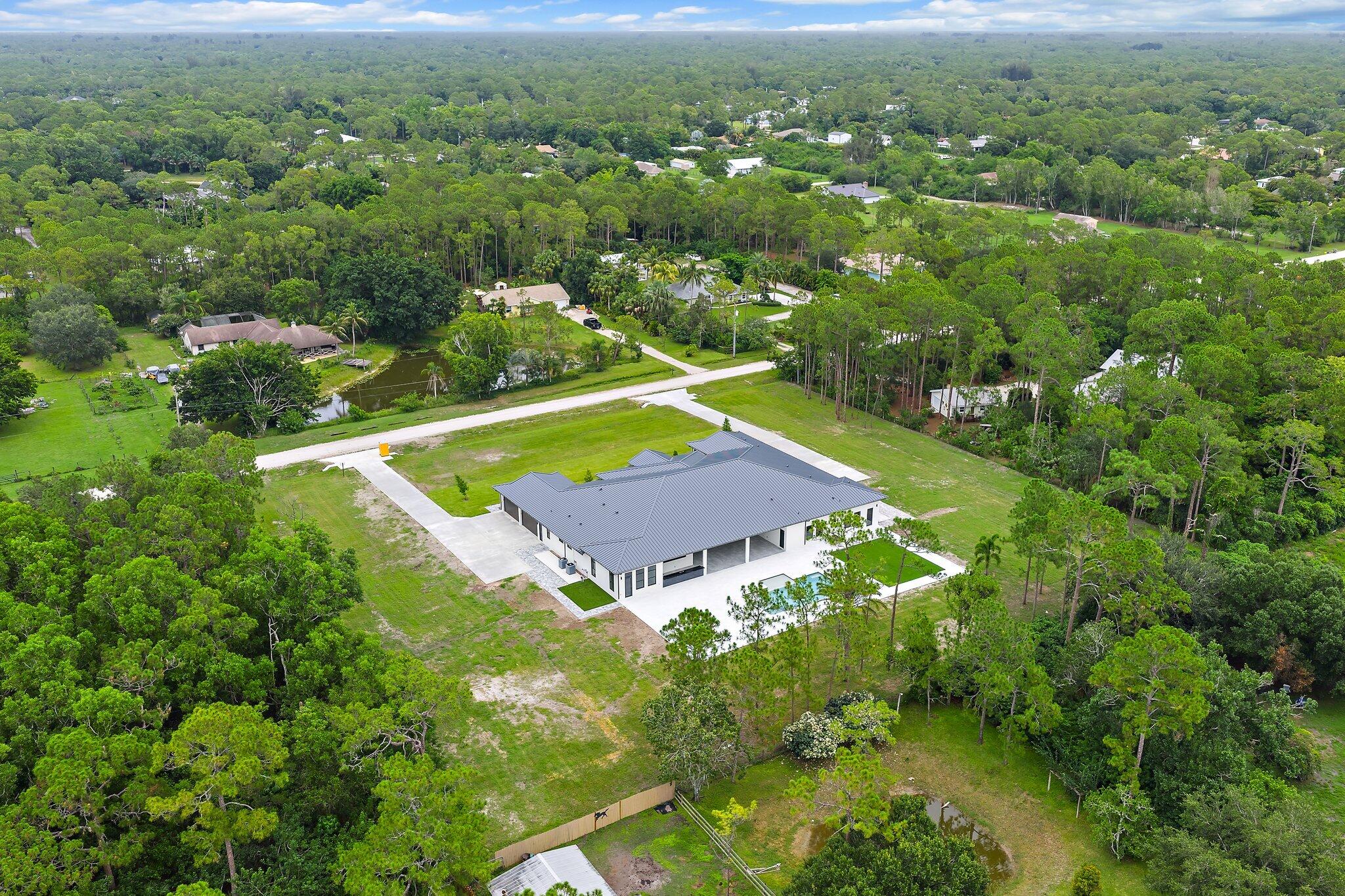 12850 152nd Street North Jupiter, FL 33478 - Photo 112 of 117 an aerial view of residential houses with outdoor space and trees
