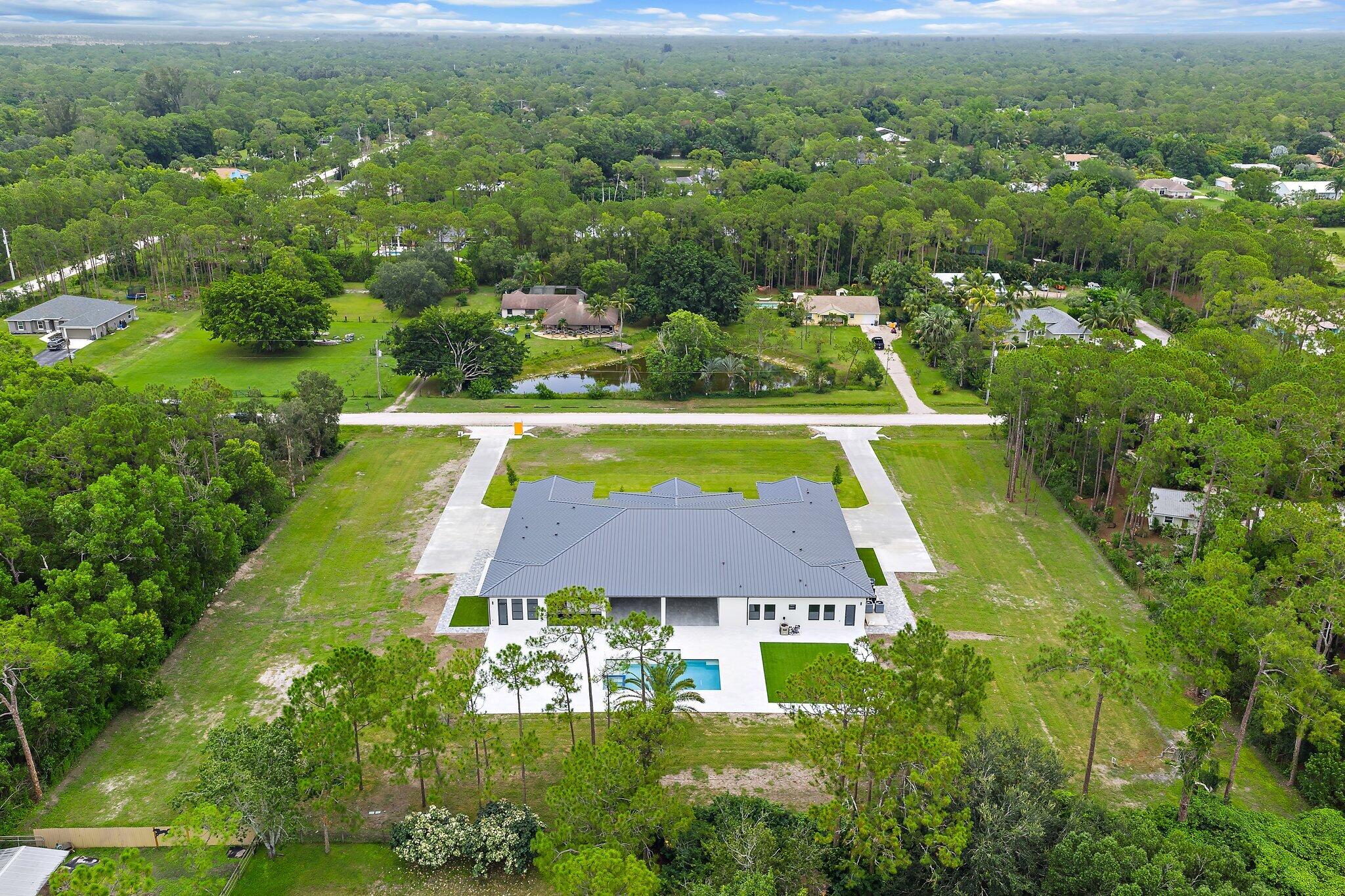 12850 152nd Street North Jupiter, FL 33478 - Photo 113 of 117 an aerial view of residential houses with outdoor space and swimming pool
