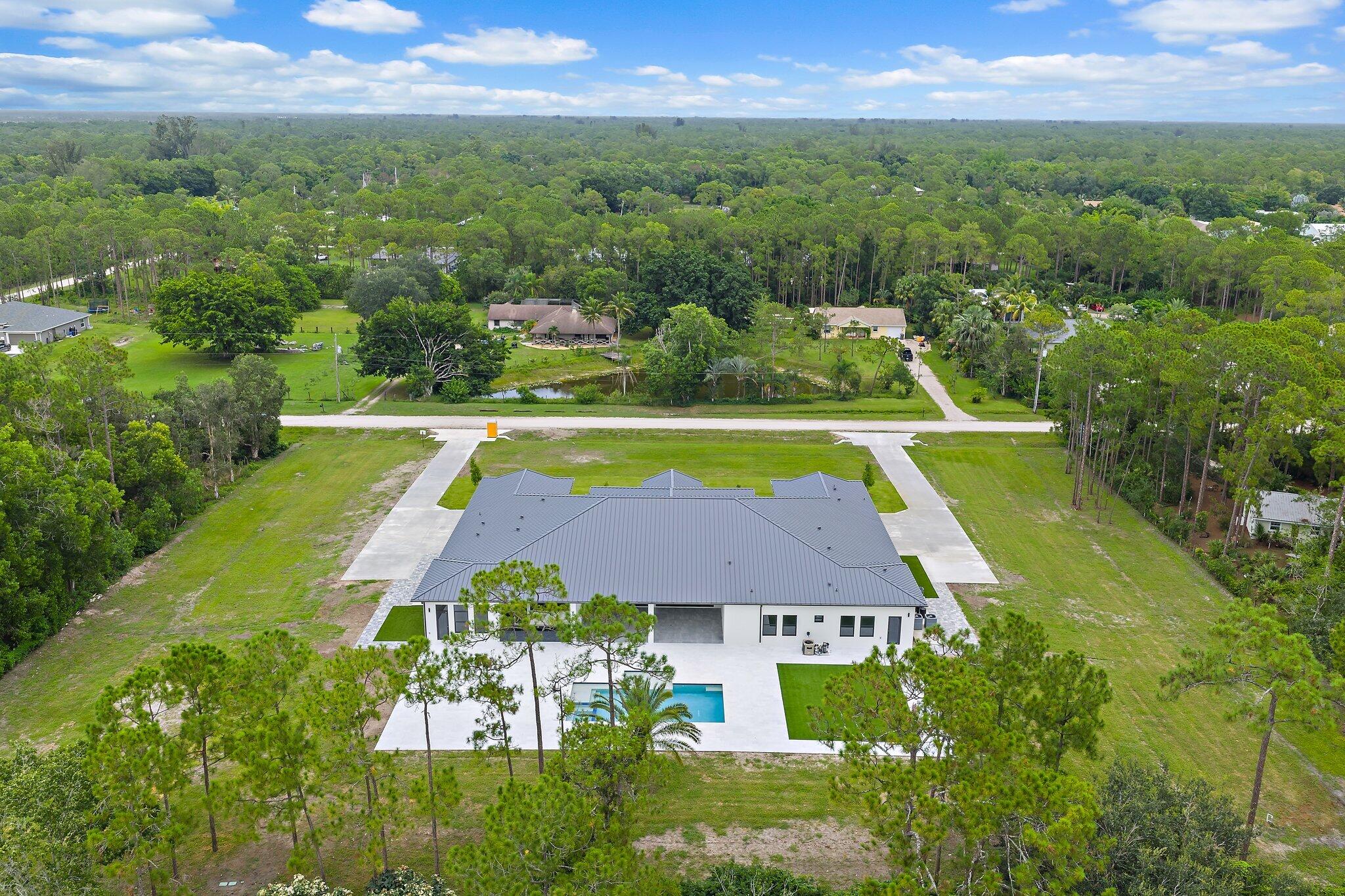 12850 152nd Street North Jupiter, FL 33478 - Photo 114 of 117 an aerial view of residential houses with outdoor space and swimming pool