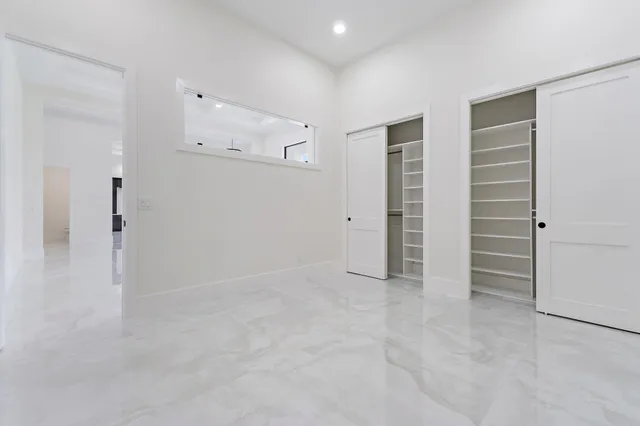 a open kitchen with stainless steel appliances granite countertop a refrigerator a oven a large window and a chandelier