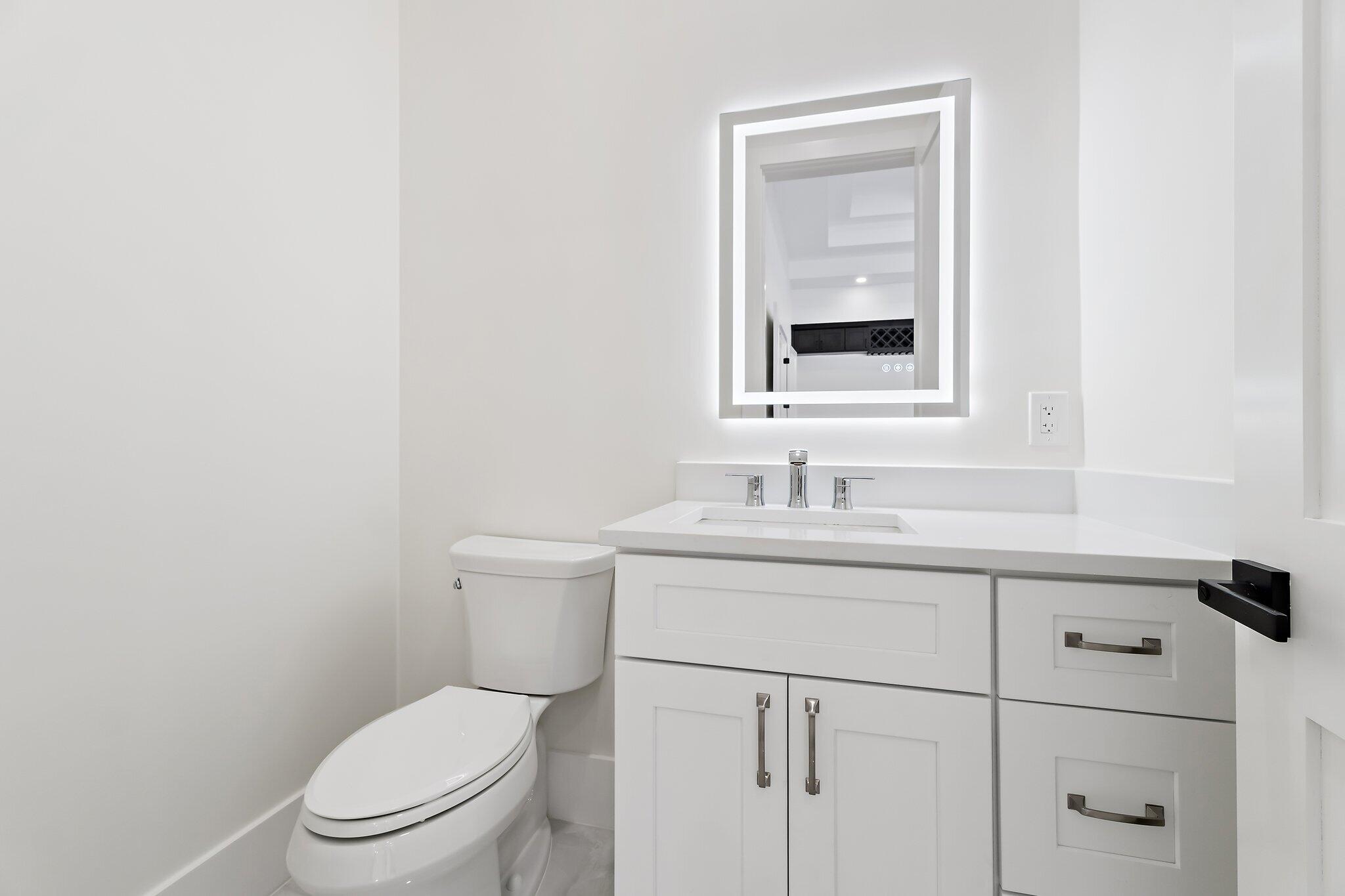12850 152nd Street North Jupiter, FL 33478 - Photo 29 of 117 a bathroom with a toilet sink vanity and mirror