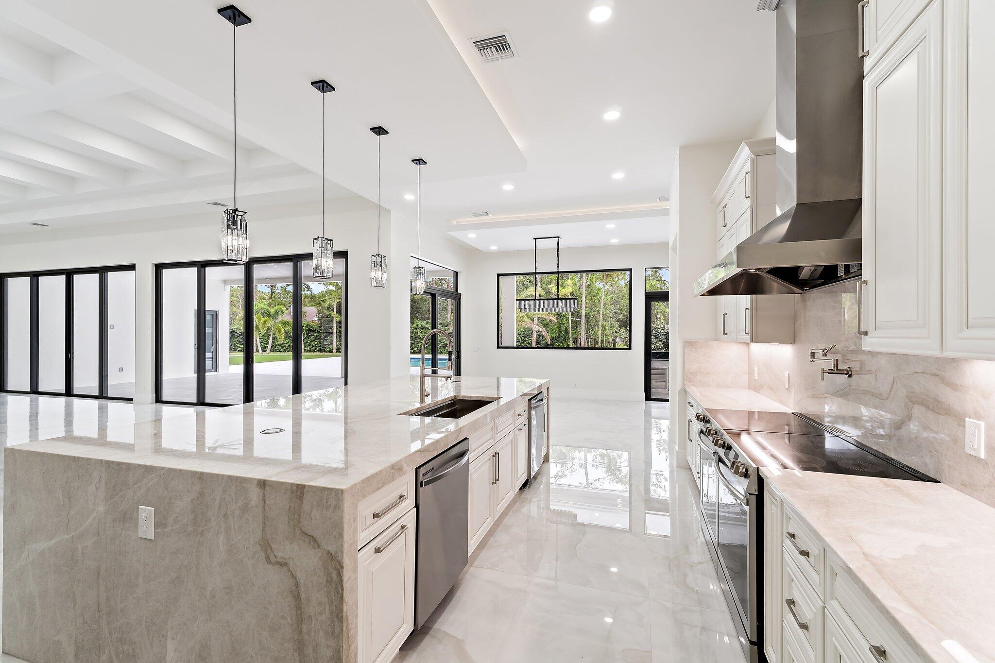 12850 152nd Street North Jupiter, FL 33478 - Photo 42 of 117 a large kitchen with stainless steel appliances kitchen island granite countertop a sink and cabinets