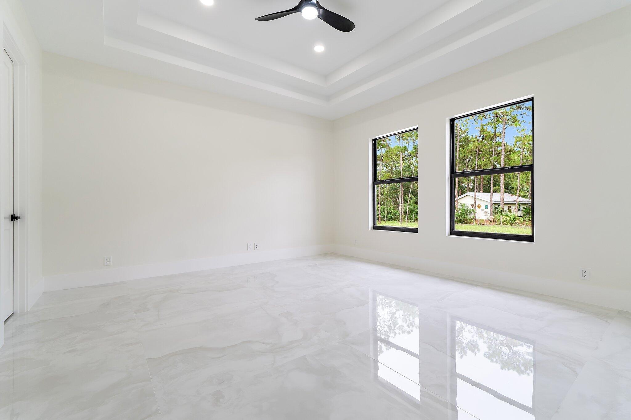 12850 152nd Street North Jupiter, FL 33478 - Photo 66 of 117 an empty room with windows and ceiling fan