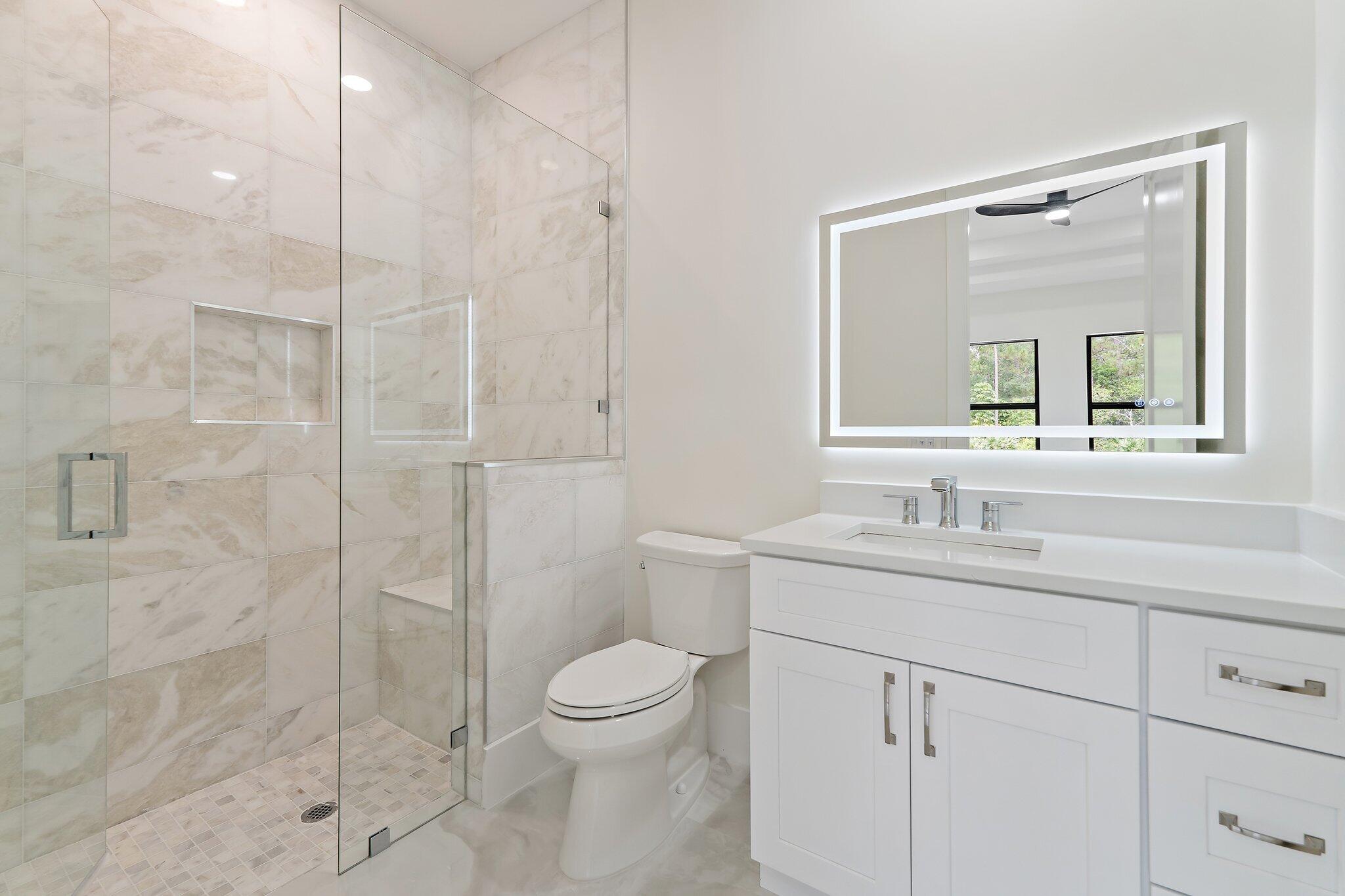 12850 152nd Street North Jupiter, FL 33478 - Photo 68 of 117 a bathroom with a toilet sink vanity granite and shower