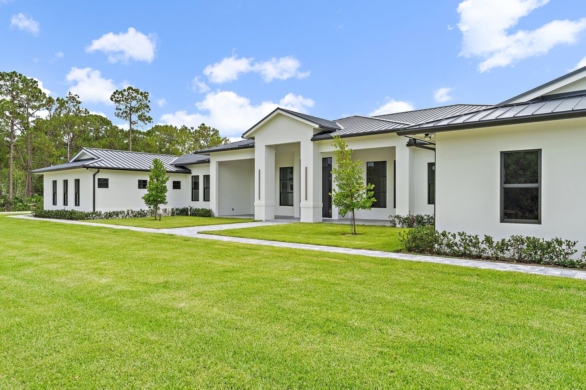 12850 152nd Street North Jupiter, FL 33478 - Photo 10 of 117 a front view of a house with a garden