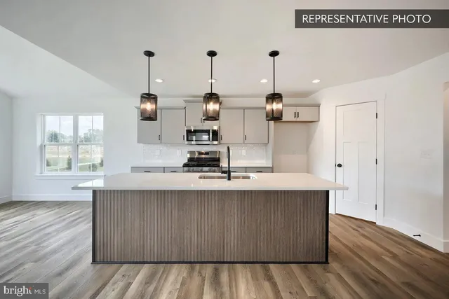 a kitchen with kitchen island a sink wooden floor and window
