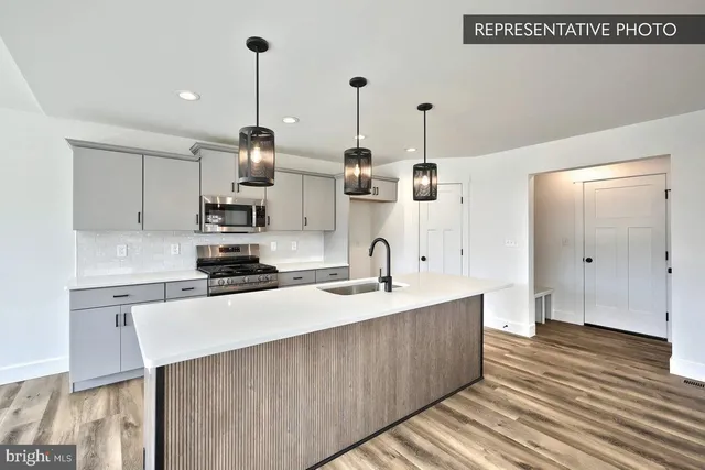 a kitchen with stainless steel appliances granite countertop a sink a stove and a wooden floors