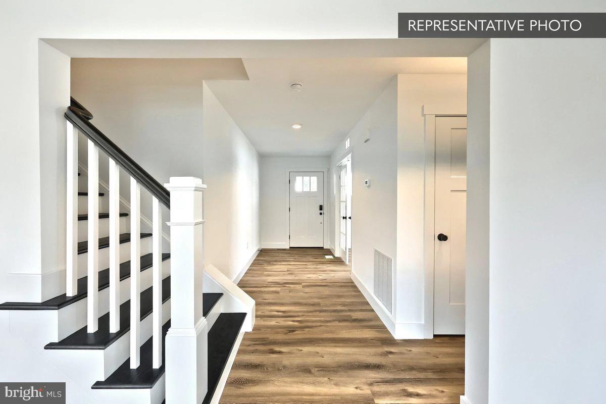 Emily Plan At The Seasons Dover, PA 17315 - Photo 8 of 27 a view of a hallway with wooden floor and staircase