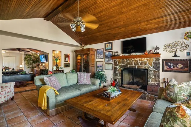 a living room with furniture a flat screen tv and a fireplace