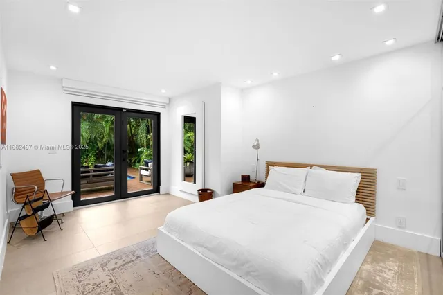 a spacious bedroom with a large bed and large windows