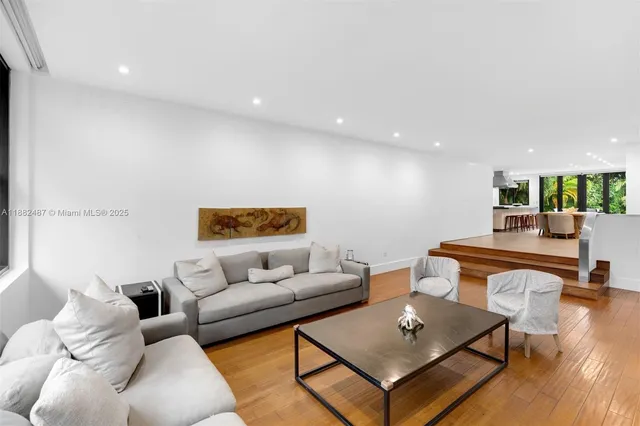 a living room with furniture and a table with wooden floor