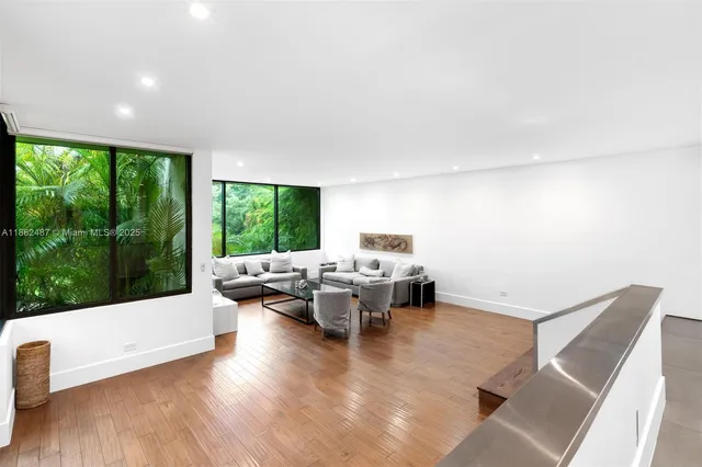 a living room with furniture and large windows