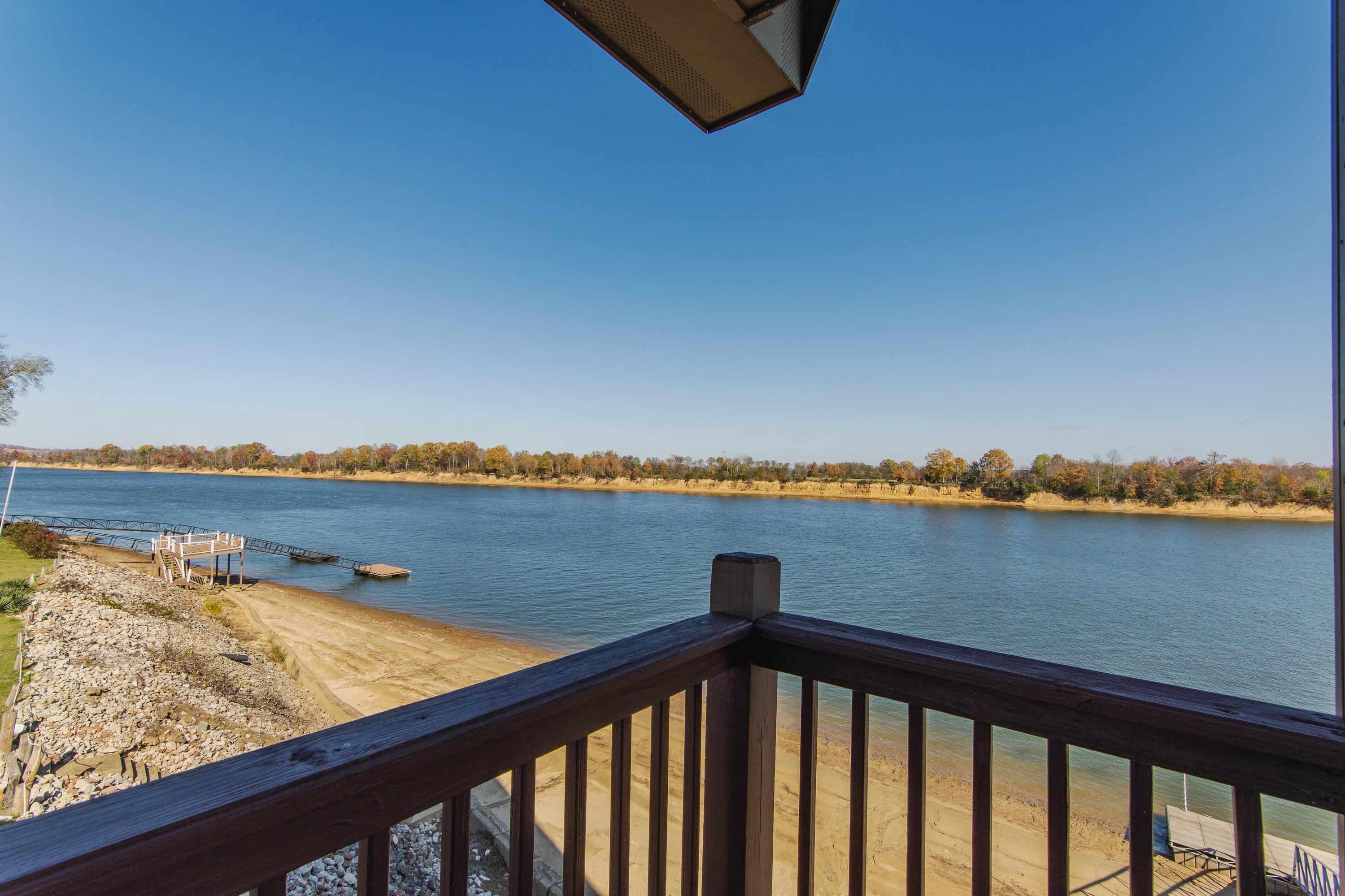 1111 Leaning Trees Lane Adamsville, TN 38310 - Photo 19 of 36 Expansive water frontage featuring a private dock and sandy shore, complemented by a protective rock embankment