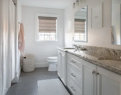 a spacious bathroom with a granite countertop toilet a sink and a mirror