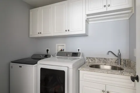 a utility room with sink dryer and washer