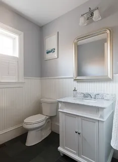 a bathroom with a toilet a sink and mirror