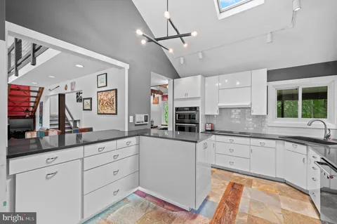 a kitchen with sink and white cabinets