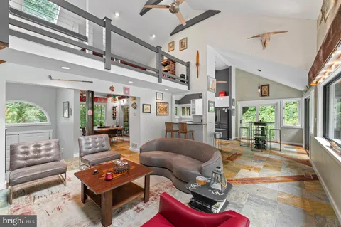 a living room with furniture a flat screen tv and a floor to ceiling window