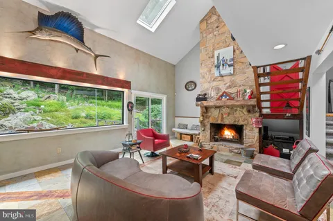 a living room with furniture a fireplace and a large window