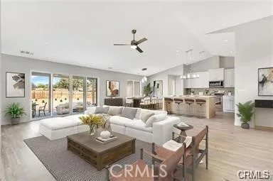 a living room with furniture kitchen view and a large window