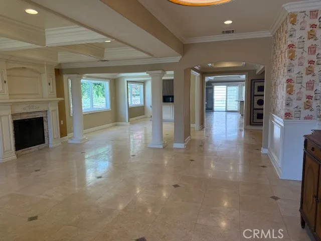 an empty room with windows and fireplace