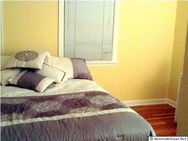 804 Allaire Road Spring Lake Heights, NJ 07762 - Photo 5 of 9 a bedroom with a bed and wooden floor