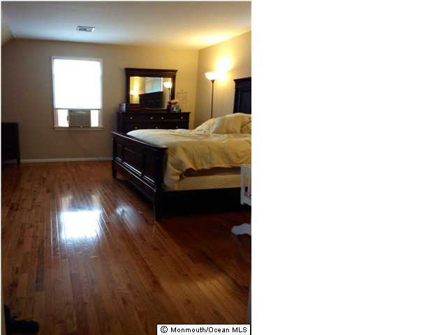 804 Allaire Road Spring Lake Heights, NJ 07762 - Photo 7 of 9 a bedroom with a bed and wooden floor