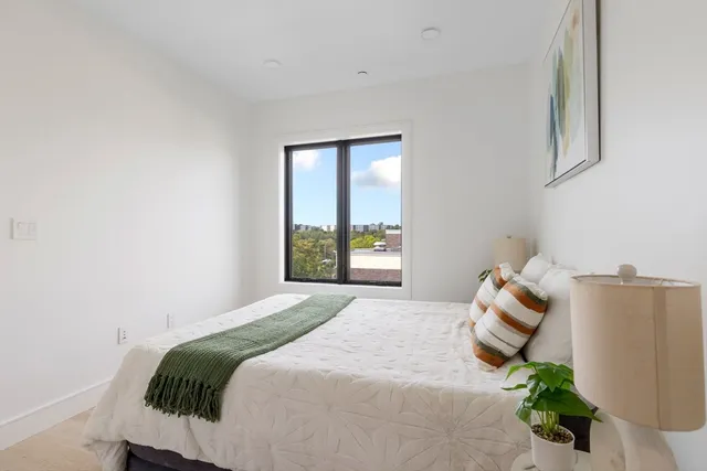 a bedroom with a bed and a large window