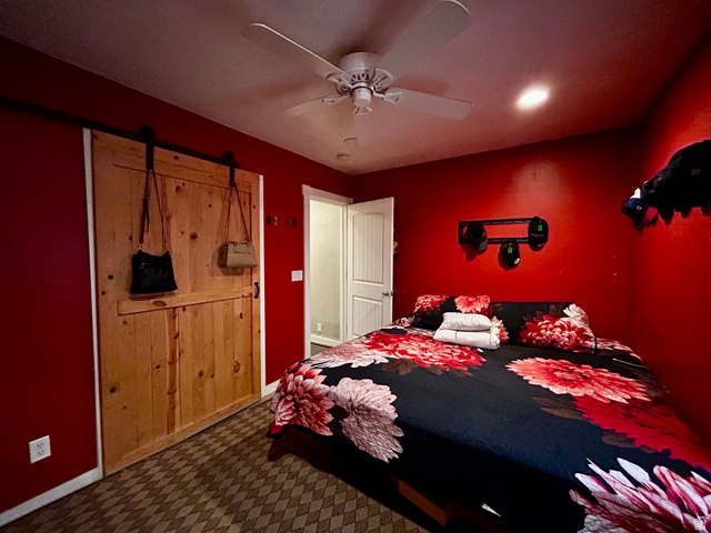 1931 Harrison Boulevard Ogden, UT 84401 - Photo 6 of 21 Bedroom #1 featuring a natural wood-finish barn door with black hardware, and a ceiling fan with integrated lighting
