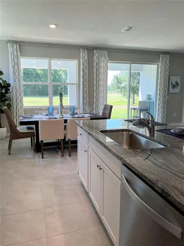a large kitchen with kitchen island a large window in it