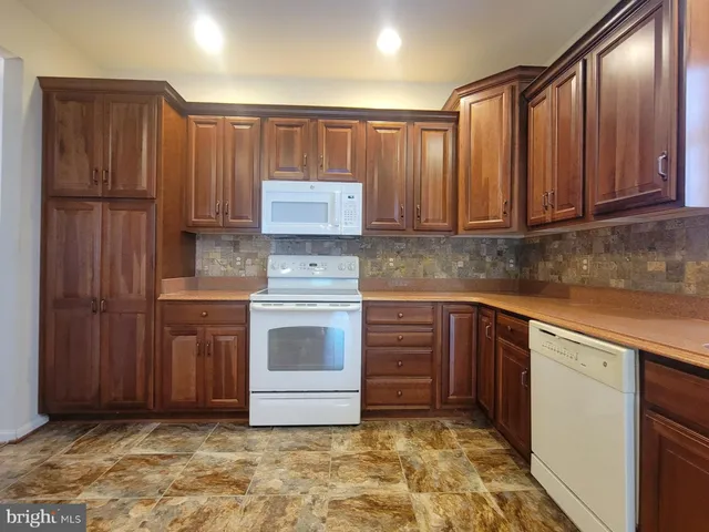 a kitchen with a stove cabinets and window
