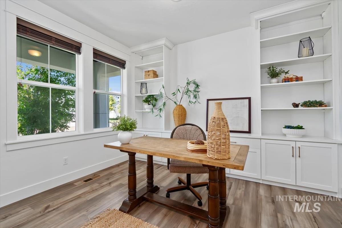 5897 West Riva Capri Street Meridian, ID 83646 - Photo 22 of 50 Bright room featuring two large windows, wood-finish flooring, and extensive built-in white cabinetry with open shelving