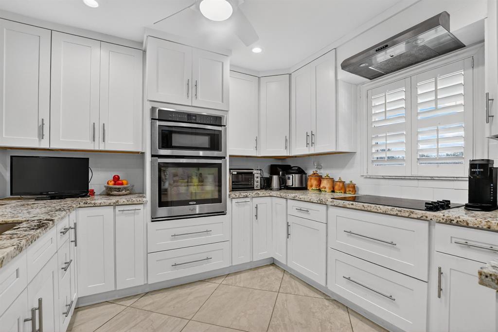 250 Northeast 20th Street, Unit 2270 Boca Raton, FL 33431 - Photo 7 of 39 a kitchen with granite countertop white cabinets and stainless steel appliances