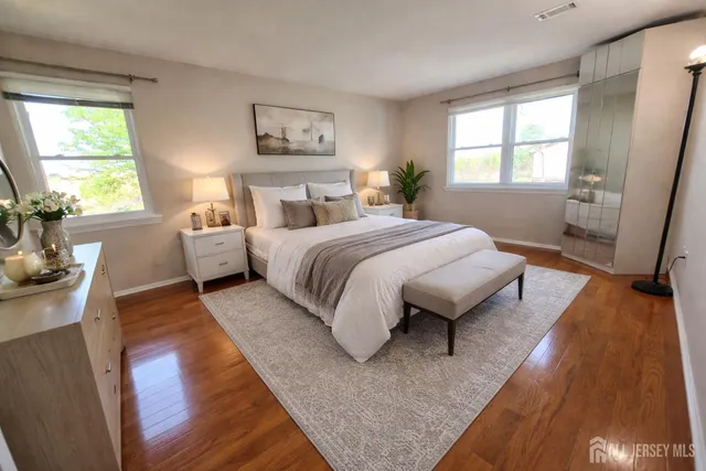 a spacious bedroom with a bed and wooden floor