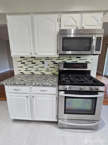 a stove top oven sitting inside of a kitchen