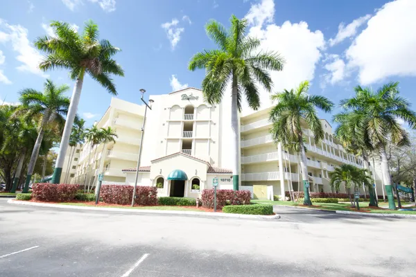 front view of a building with palm trees