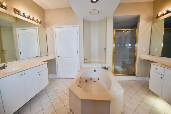 a spacious bathroom with a tub sink and mirror