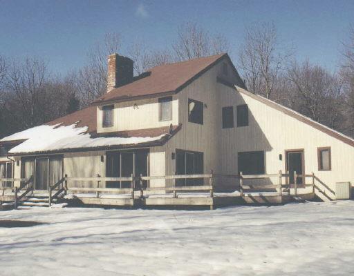 68 Seventy Acre Road Redding, CT 06896 - Photo 1 of 1 a view of a white house with large windows and couches chairs