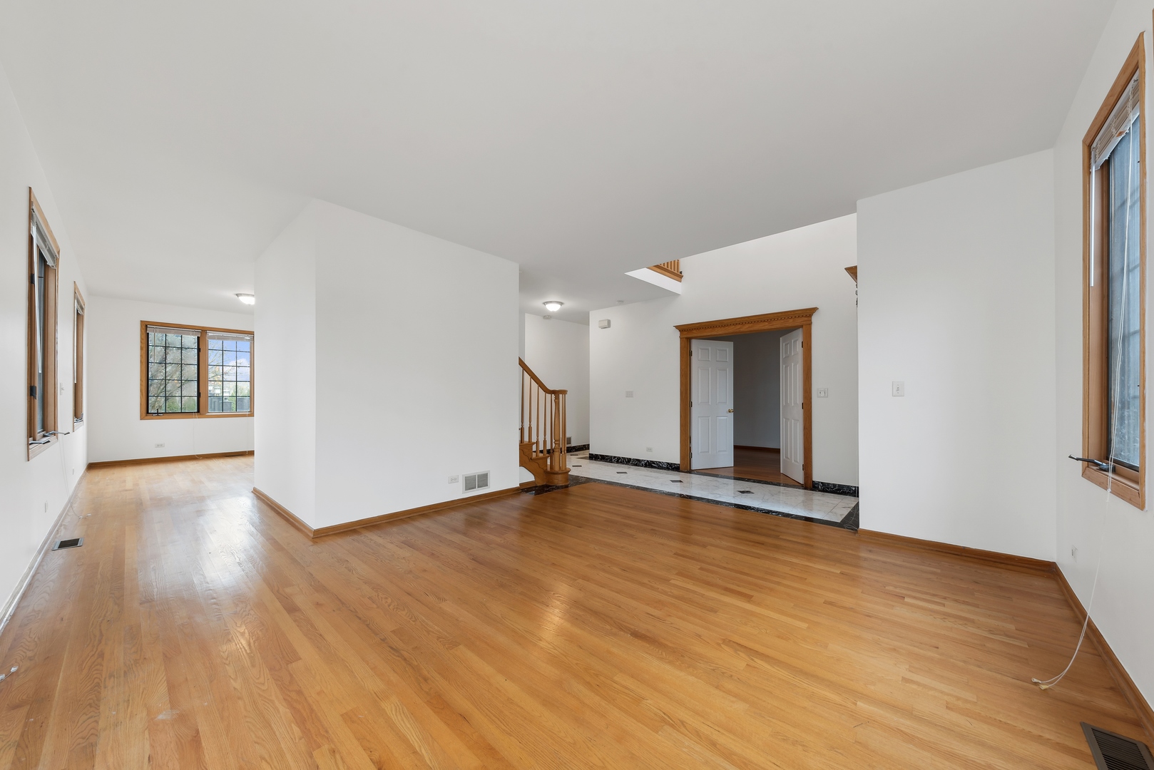 1115 South Elmhurst Road Wheeling, IL 60090 - Photo 3 of 33 a view of an empty room with wooden floor and a window