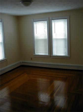 49 Dean Avenue, Unit 2 Franklin, MA 02038 - Photo 3 of 9 a view of an empty room with wooden floor and a window
