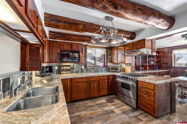 a kitchen with stainless steel appliances granite countertop a sink and stove top oven