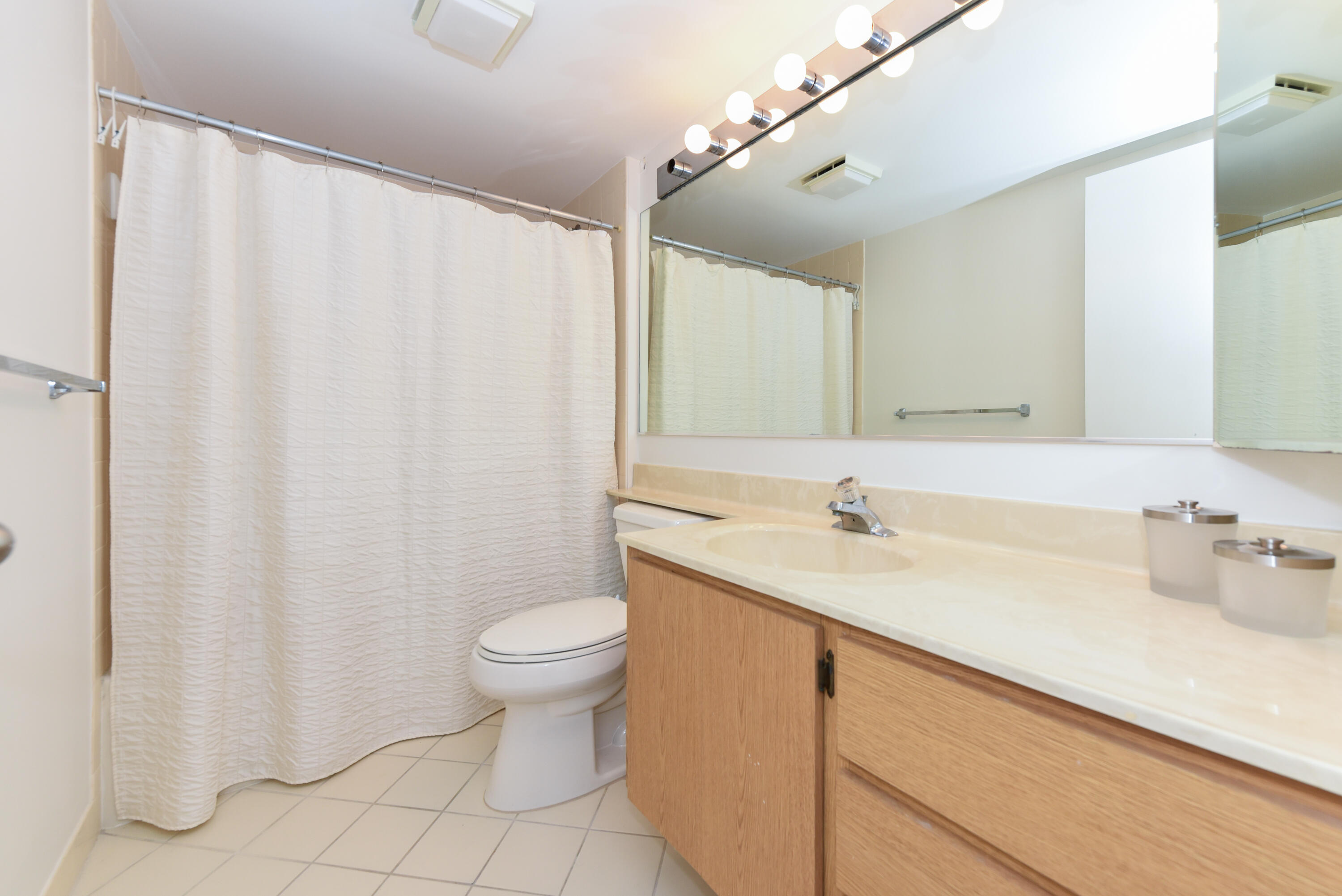 2401 Marina Isle Way, Unit 405 Jupiter, FL 33477 - Photo 20 of 30 a bathroom with a sink a toilet and a mirror