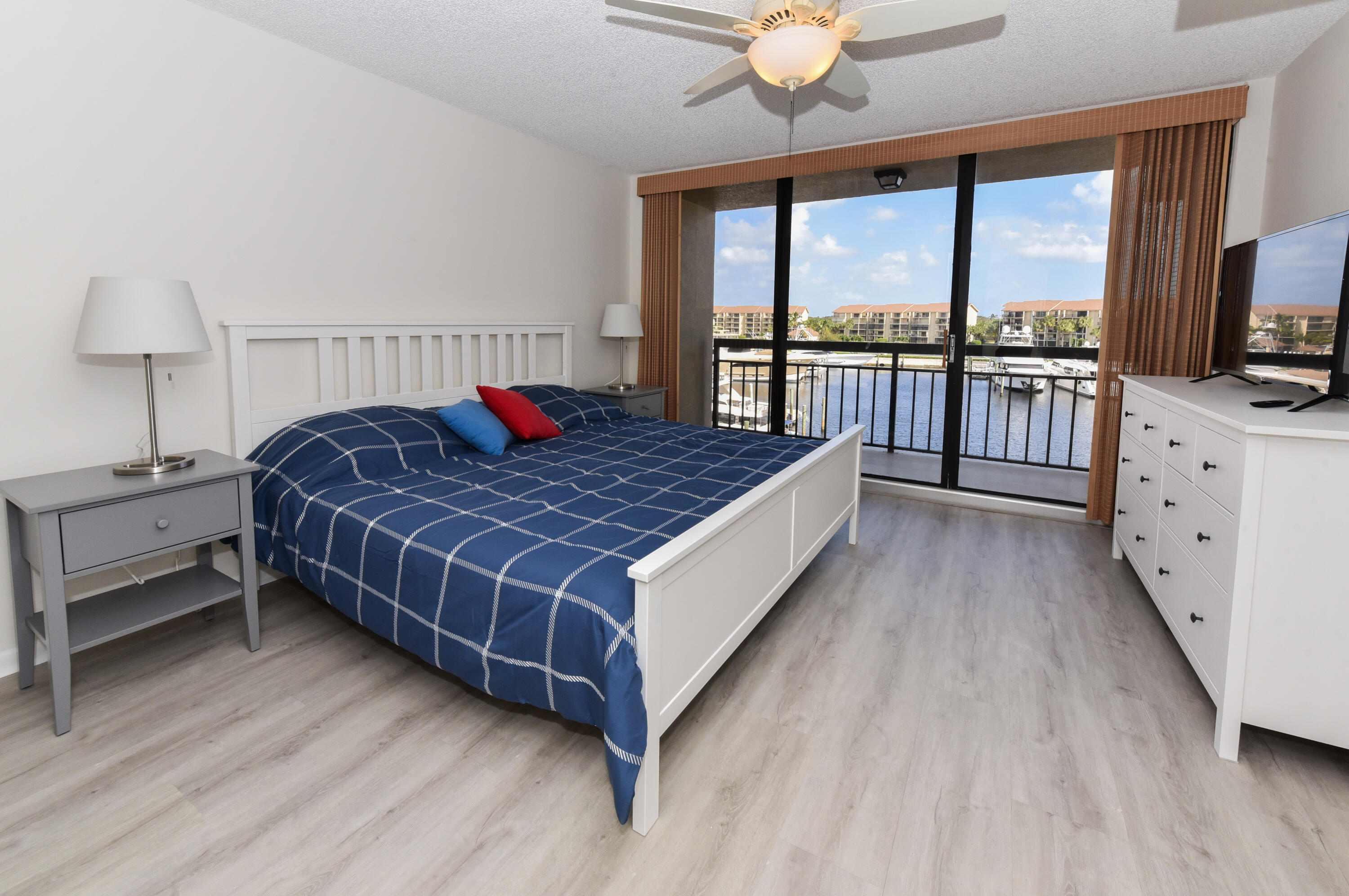 2401 Marina Isle Way, Unit 405 Jupiter, FL 33477 - Photo 21 of 30 a bedroom with a large bed and a tv